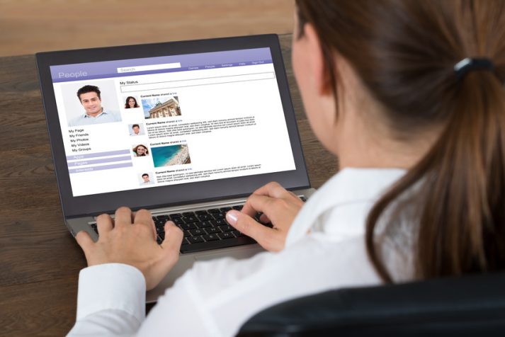 Frau chattet im social web am Laptop